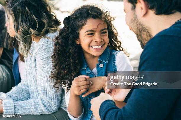 girl giving father a fist bump at beach - mum dad daughter stock pictures, royalty-free photos & images