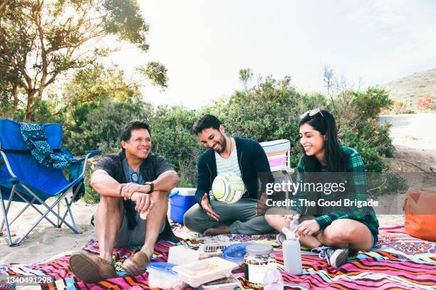 father and adult children enjoying picnic at beach - latin american and hispanic ethnicity picnic stock pictures, royalty-free photos & images