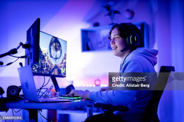 teenager gaming online in his bedroom - arts culture and entertainment stock pictures, royalty-free photos & images