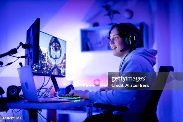 teenager gaming online in his bedroom - computer headset stock pictures, royalty-free photos & images