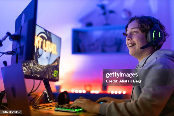 teenager gaming online in his bedroom - modern boy hipster stock pictures, royalty-free photos & images