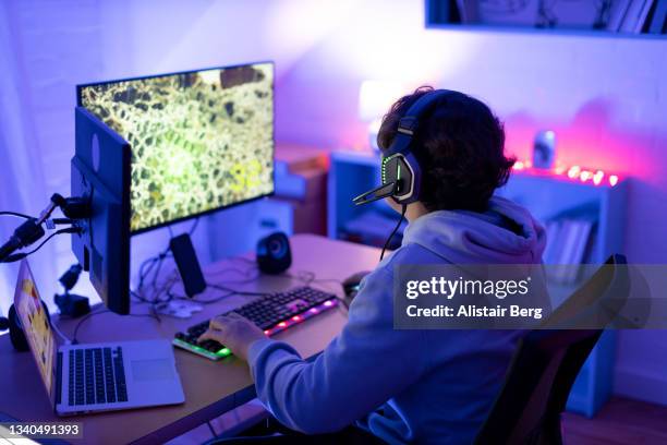 teenager gaming online in his bedroom - massively multiplayer online game stock pictures, royalty-free photos & images