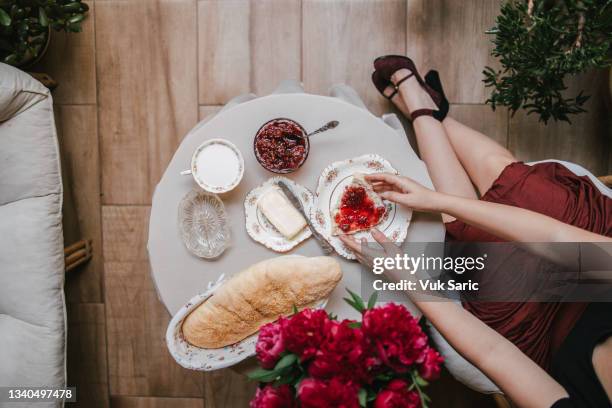 frau mit einer scheibe hausgemachtem brot mit himbeermarmelade auf - marmalade sandwich stock-fotos und bilder