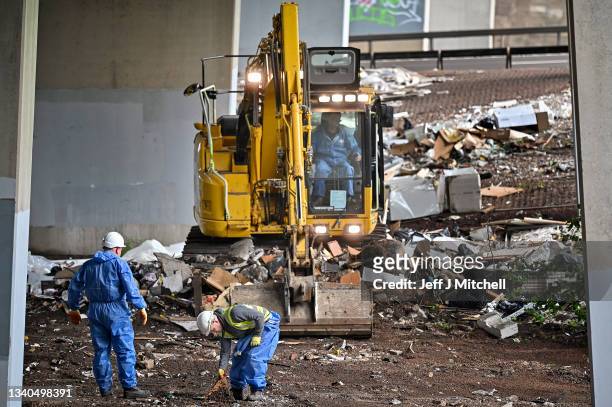 Workers remove rubbish dumped underneath the M8 motorway on September 15, 2021 in Glasgow, Scotland. Fly-tippers have been discarding refuge under a...