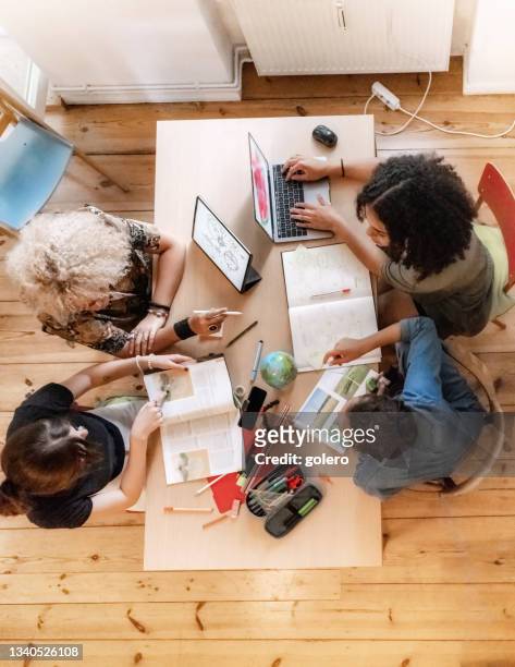 overhead view on four young woman working together on concepts at desk - studera i grupp bildbanksfoton och bilder