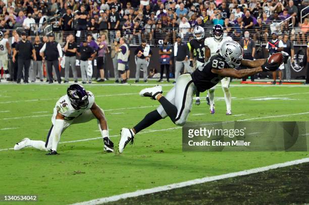 Tight end Darren Waller of the Las Vegas Raiders dives into the end zone to score a touchdown on a 10-yard pass play after spinning away from...