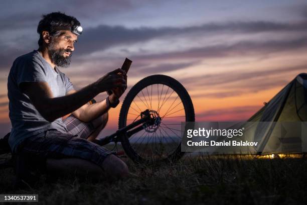 mountain biking and camping at sunset. - car light bildbanksfoton och bilder