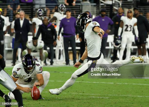 Punter Sam Koch of the Baltimore Ravens holds for kicker Justin Tucker of the Baltimore Ravens as he kicks a 47-yard field goal against the Las Vegas...