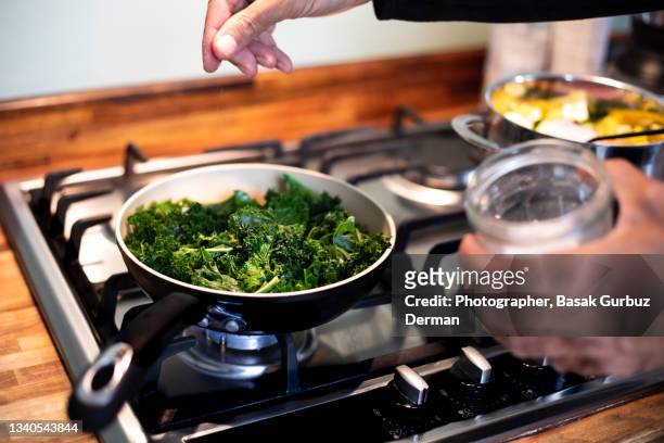 cooking sautéed kale with garlic and olive oil - leaf vegetable stock pictures, royalty-free photos & images