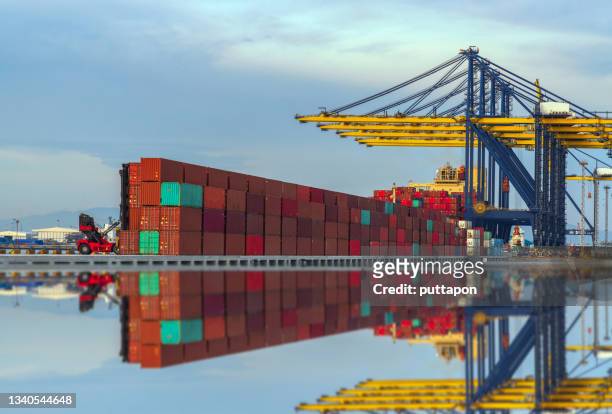 container cargo with beautiful sky, load or unload container at working crane bridge in terminal commercial port transporting shipment container for business logistics, import export, shipping or freight transportation - skybox stockfoto's en -beelden