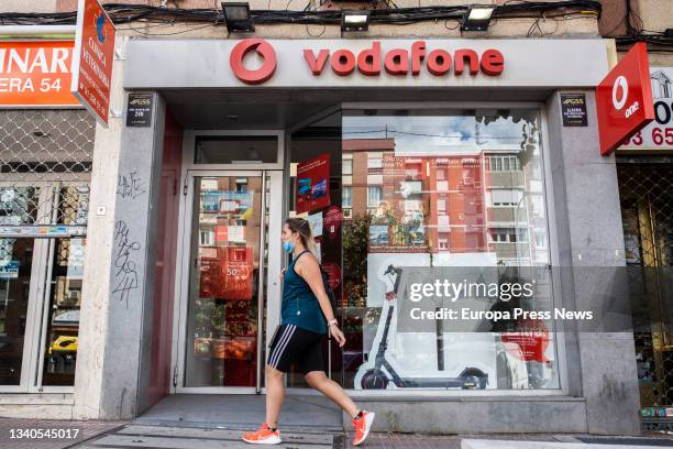 Person walks past a Vodafone store in Madrid on the day the phone company announced a redundancy plan for 515 employees on 15 September 2021 in...