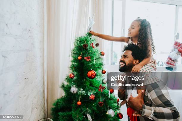 padre e figlia che decorano l'albero di natale - decorare l'albero di natale foto e immagini stock