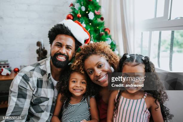 familie macht selfie lächelnd und feiert weihnachten zu hause - african american christmas images stock-fotos und bilder