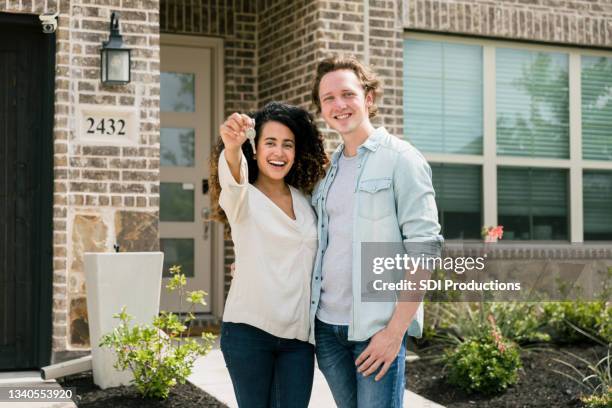 couple proudly shows off key to new home - millennial home ownership stock pictures, royalty-free photos & images