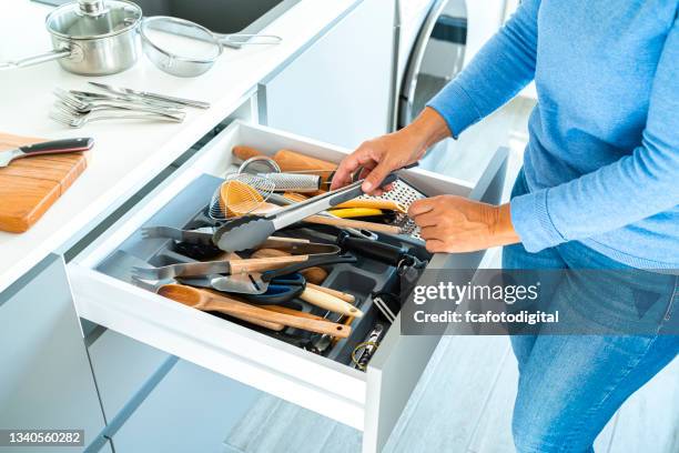woman sorting out messy kitchen drawer - drawer stock pictures, royalty-free photos & images