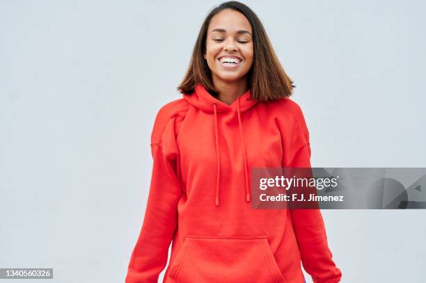 portrait of smiling woman with red sweatshirt on white background - sweatshirt fotografías e imágenes de stock