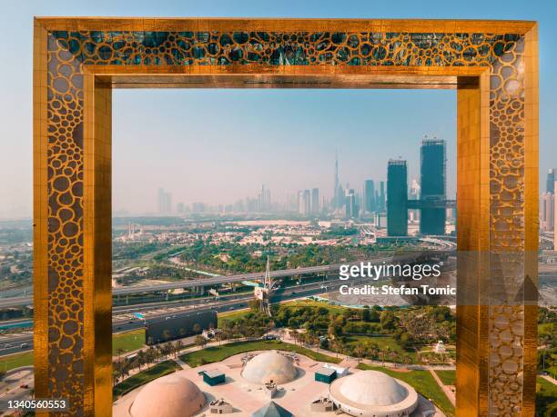 aerial view of dubai frame with downtown area skyline rising above in the united arab emirates - dubai frame stockfoto's en -beelden