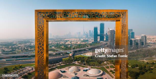 aerial view of dubai frame with downtown area skyline rising above in the united arab emirates - dubai frame stockfoto's en -beelden