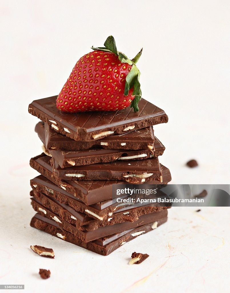 Strawberry on pile of chocolate squares