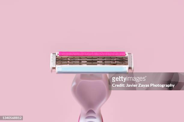 pink razor blade on pink background - scheermes stockfoto's en -beelden