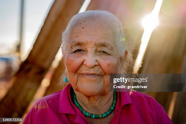 retrato da mulher nativa americana navajo idosa sorrindo do lado de fora em seu quintal em um dia ensolarado vestindo autênticas joias navajo turquoise - etnia cheroqui - fotografias e filmes do acervo