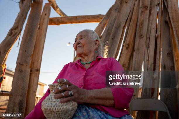 retrato da mulher nativa americana navajo idosa sorrindo do lado de fora em seu quintal em um dia ensolarado vestindo autênticas joias navajo turquoise - reserva navajo - fotografias e filmes do acervo