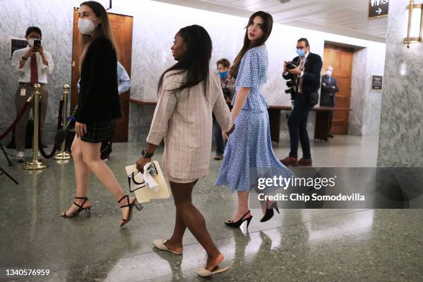 Former U.S. Olympic gymnasts McKayla Maroney and Simone Biles hold hands as they leave following their testimony before the Senate Judiciary...