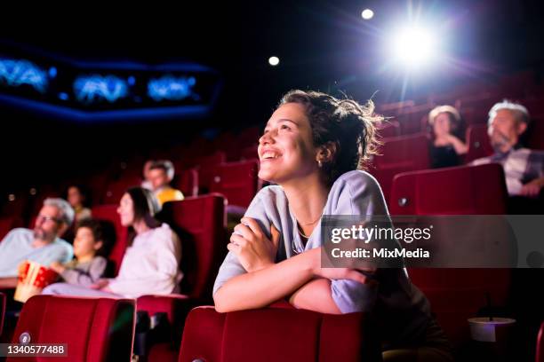 girl enjoying watching a nice movie at the cinema - première stockfoto's en -beelden