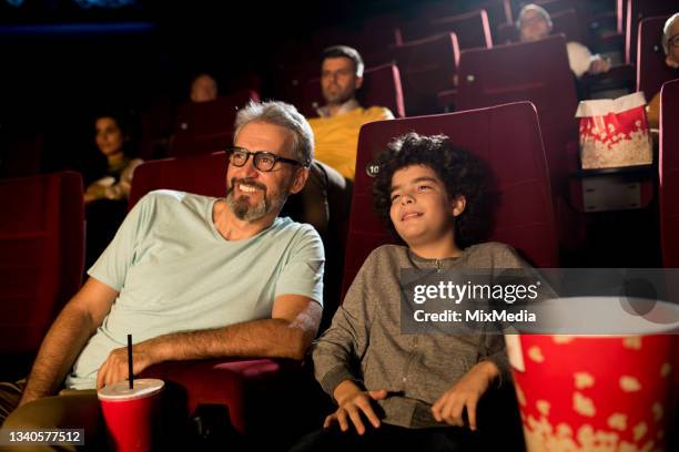 boy enjoying with dad at the cinema - good boy premiere stock pictures, royalty-free photos & images