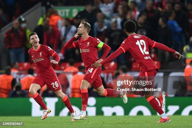 Jordan Henderson of Liverpool celebrates with teammates Joe Gomez and Andrew Robertson after scoring their side's third goal during the UEFA...