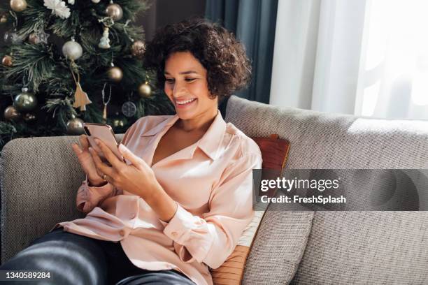 beautiful woman using mobile phone at home - december 1 stock pictures, royalty-free photos & images