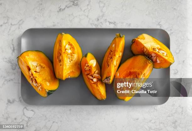 sliced kabocha on a tray on white, marble background - squash seeds bildbanksfoton och bilder