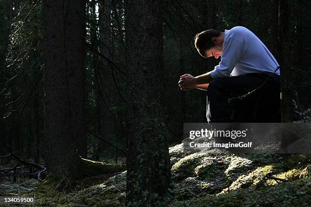 man praying in the forest - bidden stockfoto's en -beelden