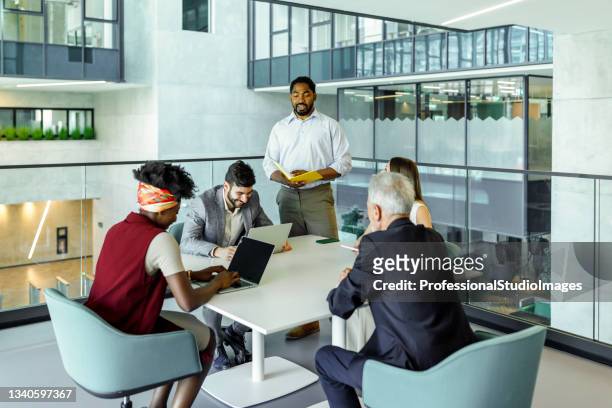geschäftskollegen arbeiten und genießen die teamarbeit im firmengebäude mit einem afroamerikanischen manager. - office small business stock-fotos und bilder