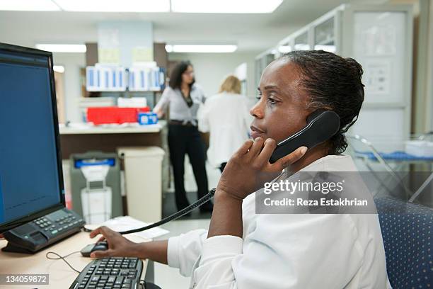 pharmacist on telephone checks doctors orders - pharmacist phone stock pictures, royalty-free photos & images