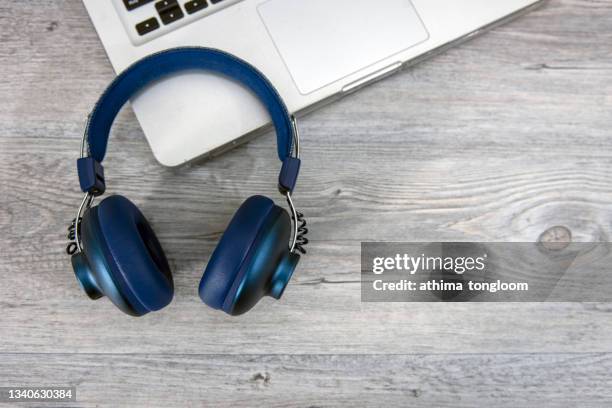 headphones on laptop. - bluetooth headphones stock pictures, royalty-free photos & images