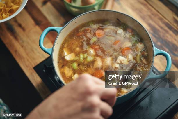 preparing chicken noodles soup with fresh vegetables - minestrone stockfoto's en -beelden