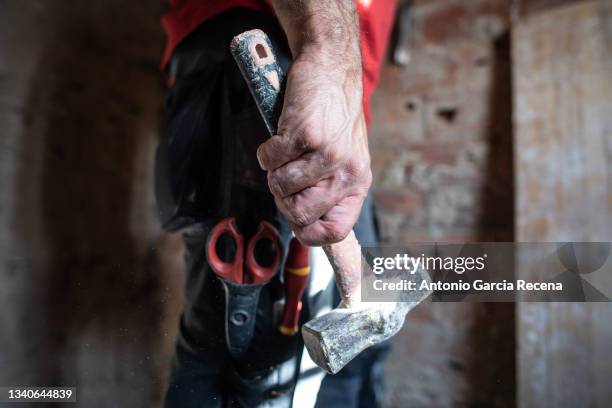 a hand with a hammer, real worker close up detail image - martillo herramienta de mano fotografías e imágenes de stock