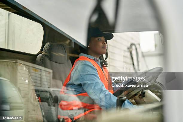 black female truck driver photographed through window - infrastructuur stockfoto's en -beelden