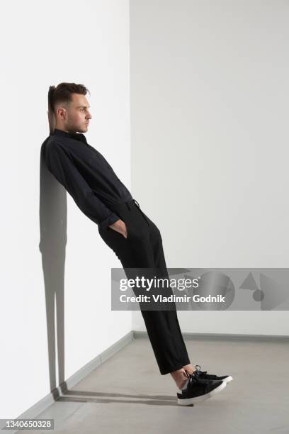 young man leaning against wall - hands in pockets stock pictures, royalty-free photos & images