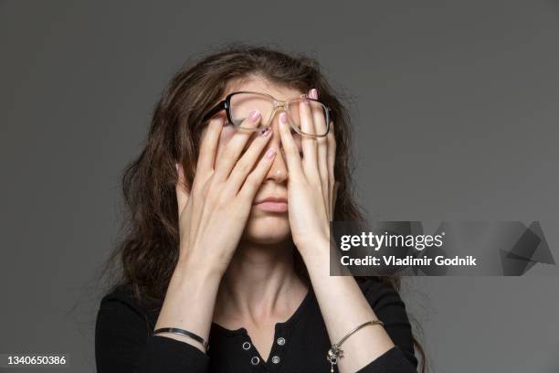 tired young woman rubbing eyes - tired eyes stock pictures, royalty-free photos & images