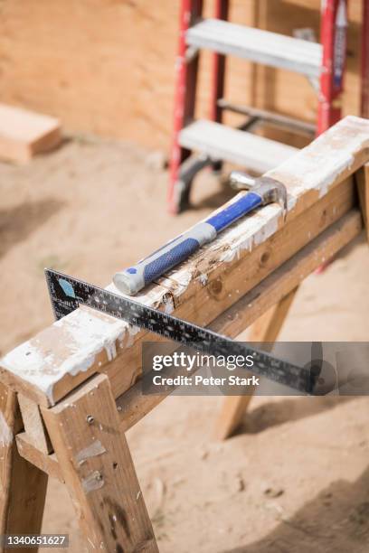 hammer and carpenter square ruler at construction site - sawhorse stock pictures, royalty-free photos & images