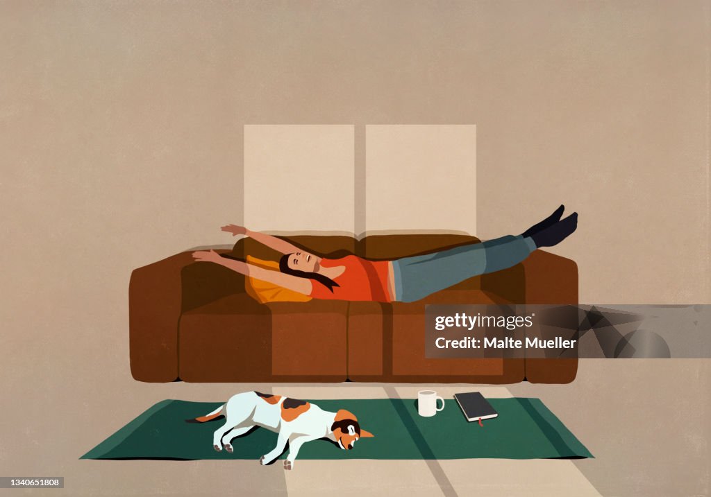 Carefree woman stretching on sofa in sunny living room