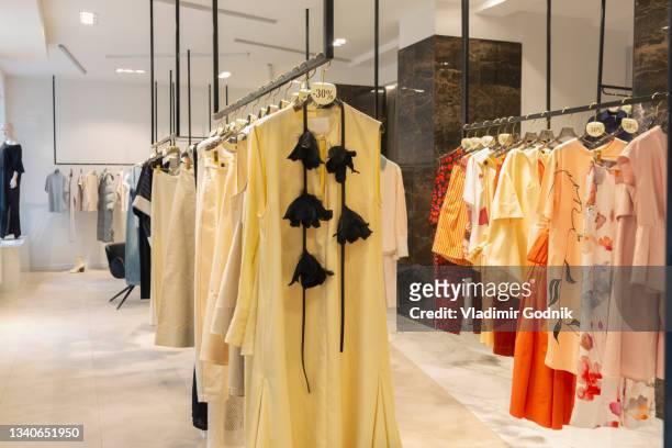 clothing on racks in boutique - garment rack stock pictures, royalty-free photos & images