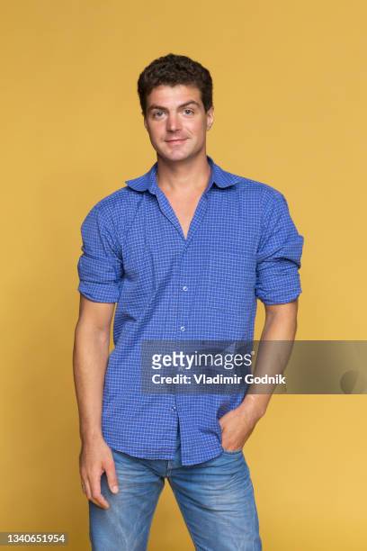 portrait confident man in blue on yellow background - three quarter length fotografías e imágenes de stock