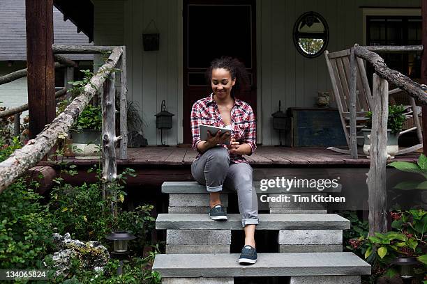 woman with digital tablet on porch - woodstock new york state stock pictures, royalty-free photos & images