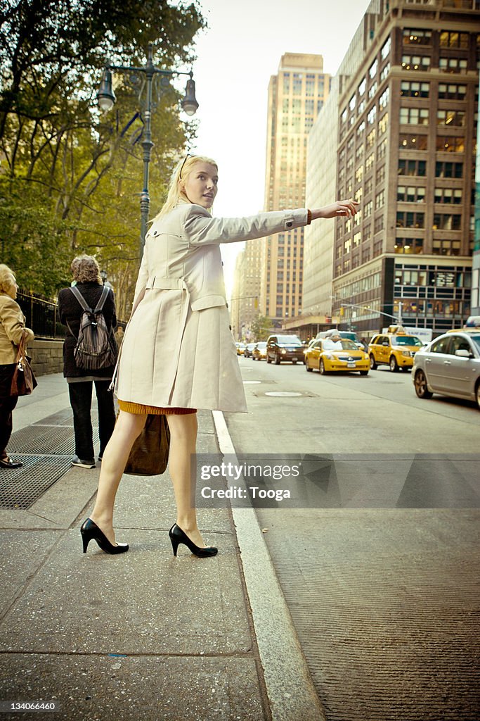 Businesswoman trying to catch a cab at rush hour