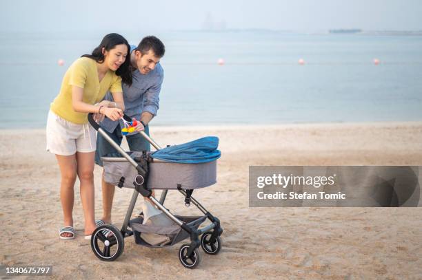 happy family with a newborn baby by the sea - happy arab family on travel stockfoto's en -beelden