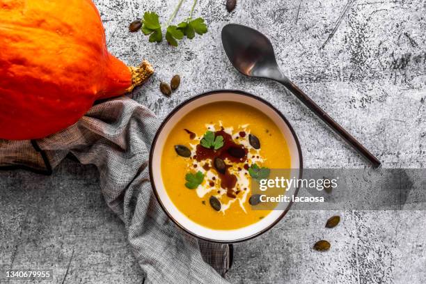 bowl of creamed pumpkin soup with cream and seeds - soup vegtables stock-fotos und bilder