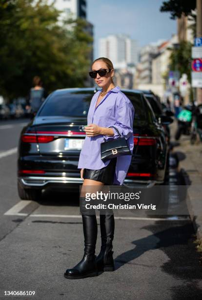 Sonia Lyson is seen wearing purple oversized button shirt, black skirt, boots, Balenciaga bag during About You Fashion Week on September 15, 2021 in...